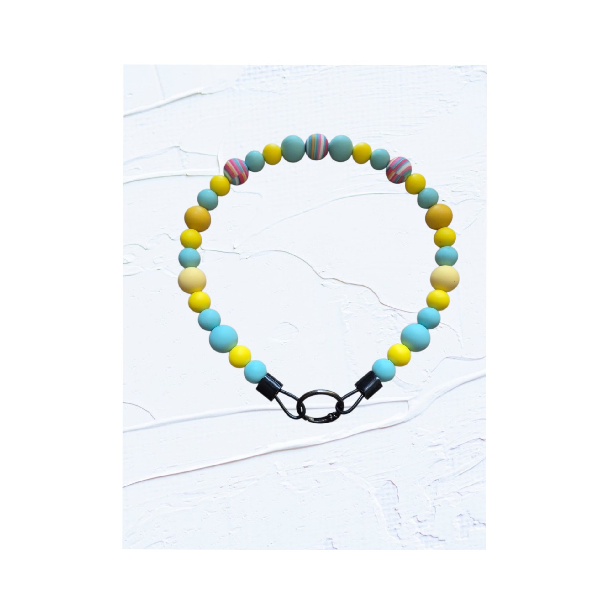  teal, yellow and cream beads with multicolour swirl accent bead and black O-ring clasp